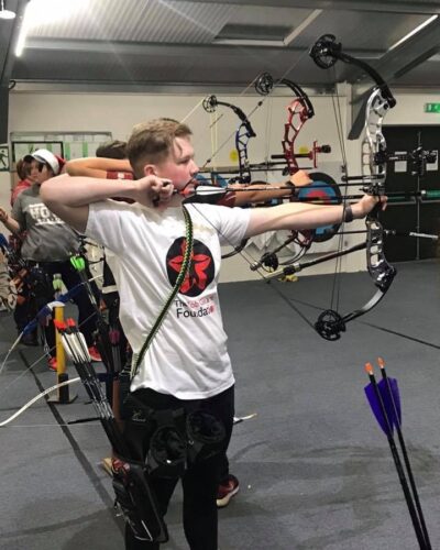 Nathan shooting arrow at archery charity event