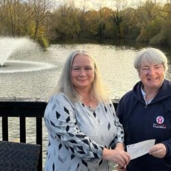 Justina presenting a cheque to Lorraine George.