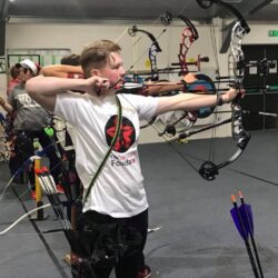 Nathan shooting arrow at archery charity event